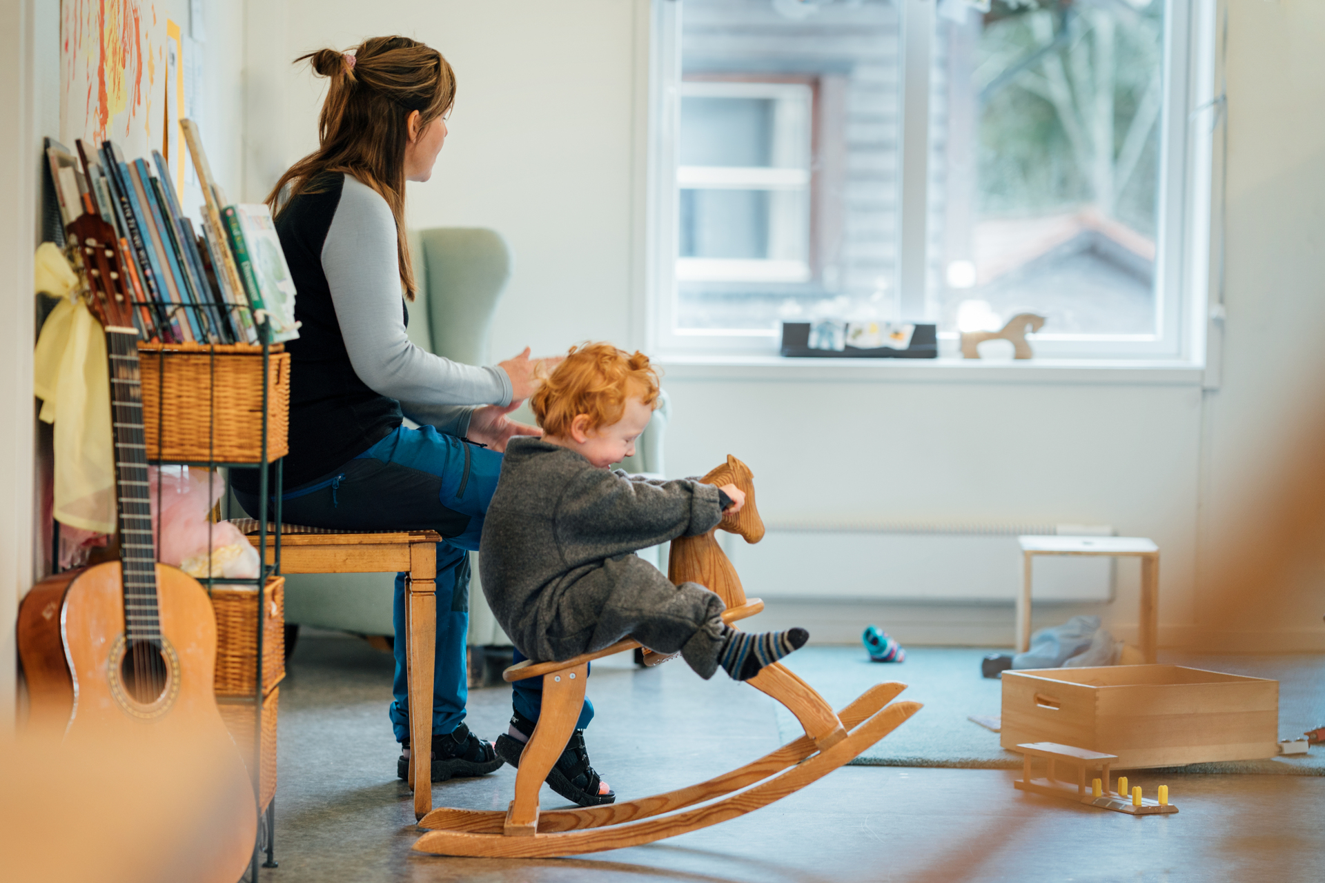 barn på gunghäst bredvid mamma