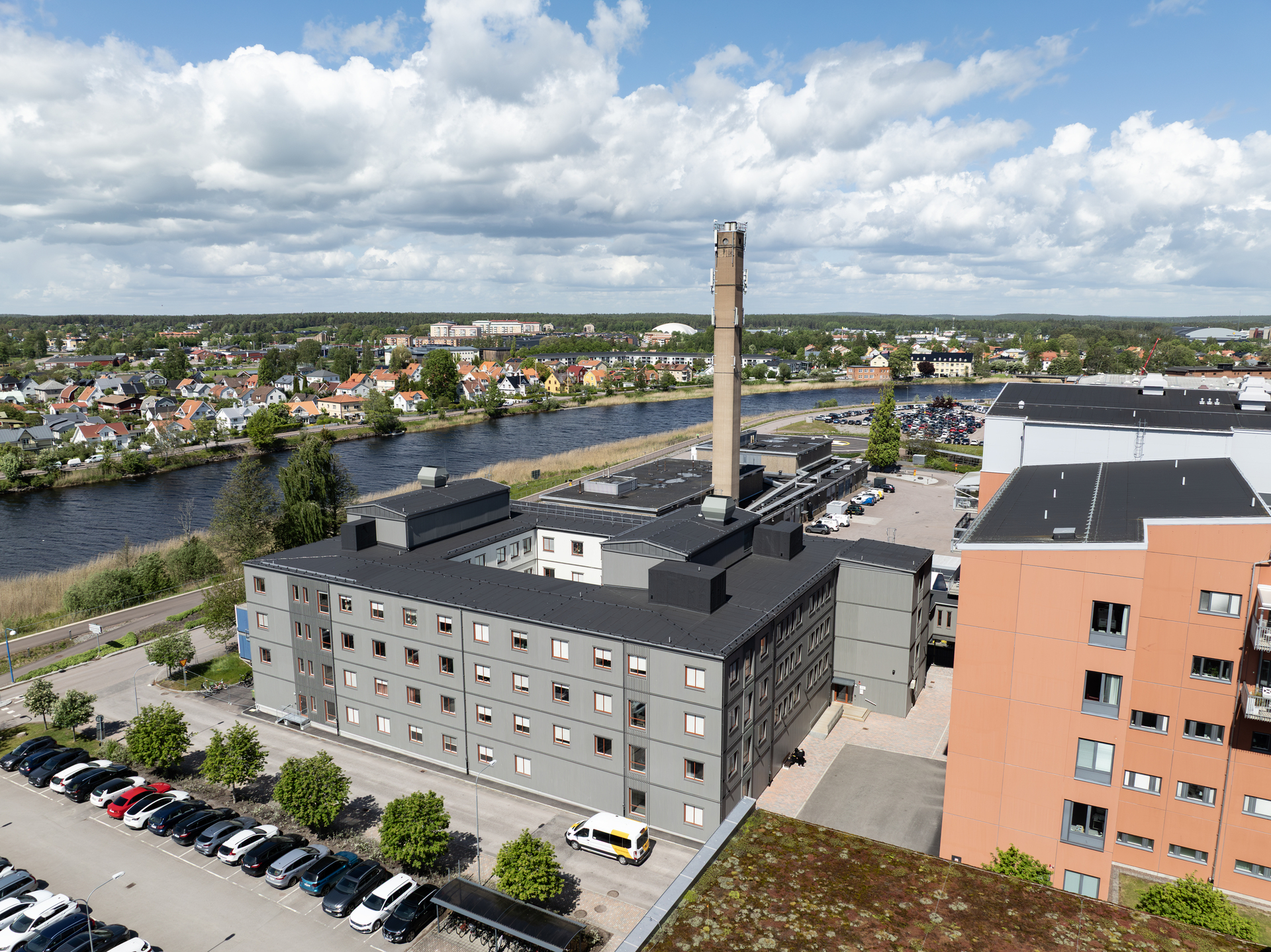 Flygvy över Centralsjukhuset i Karlstad med intilliggande kontorsmoduler från Expandia. De moderna modulbyggnaderna ligger längs älven och är integrerade i sjukhusområdet, med närhet till befintliga vårdbyggnader, parkering och stadsmiljö. Bilden visar hur Expandias kontorsmoduler skapar flexibla och effektiva arbetsytor i ett centralt och lättillgängligt läge.