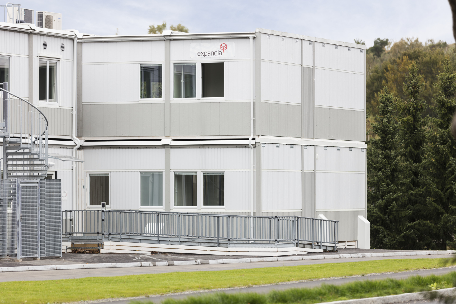 Exteriör av skolmodullösning från Expandia vid Kronängsskolan i Borås, med två våningar, ljusa fasader, ramp och omgivande grönska.