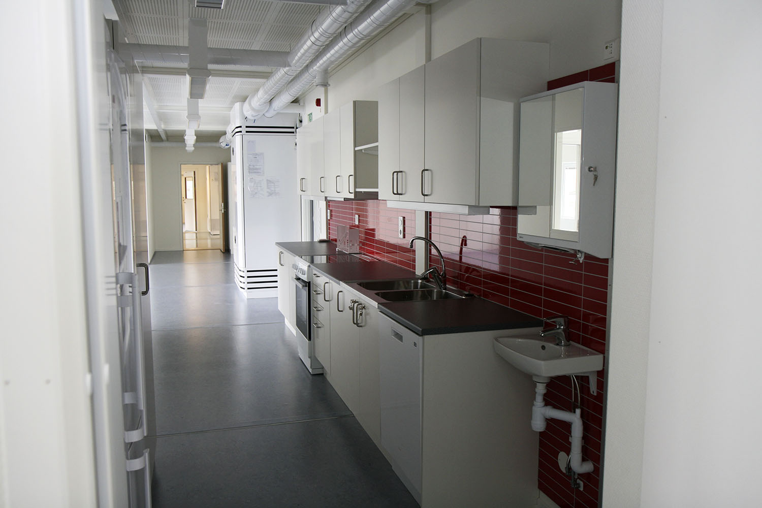 Pentry i skolmiljö med arbetsbänk, diskho, förvaring och vitvaror, placerat i en modullösning från Expandia anpassad för utbildningsverksamhet.