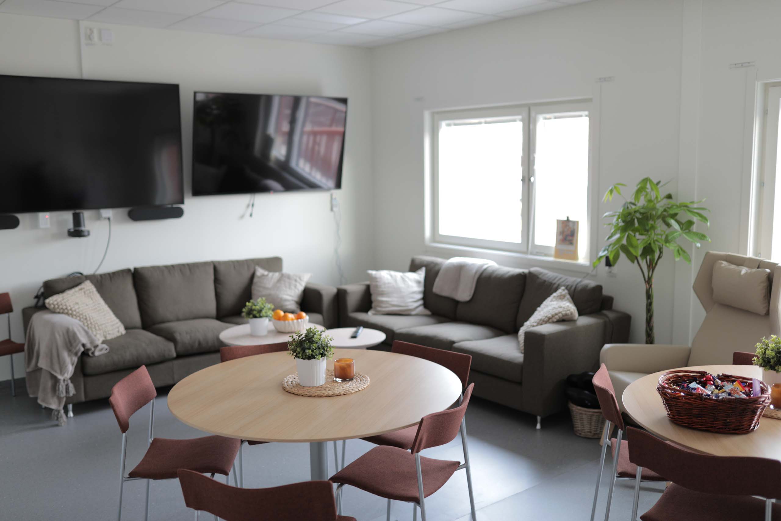 Personalrum med soffor, matbord och väggmonterade tv-skärmar i modulsjukhus från Expandia vid Centralsjukhuset Karlstad