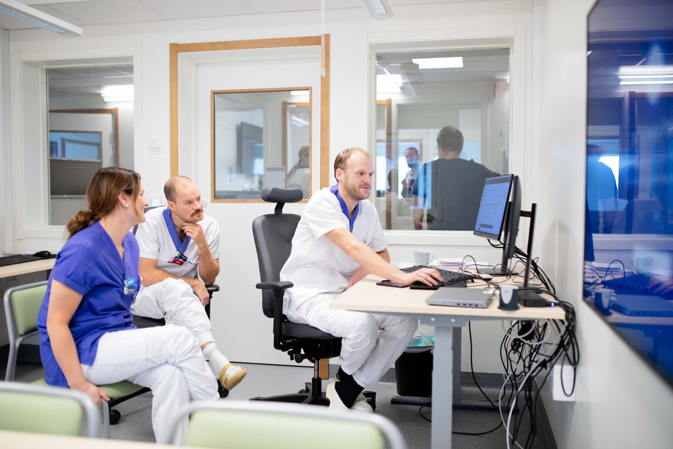Vårdpersonal i samtal vid dator på Centralsjukhuset Karlstad i modulsjukhus från Expandia